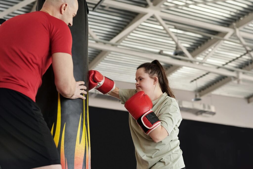 Une jeune femme bénéficie d’un cours de boxe adapté avec un éducateur sportif certifié