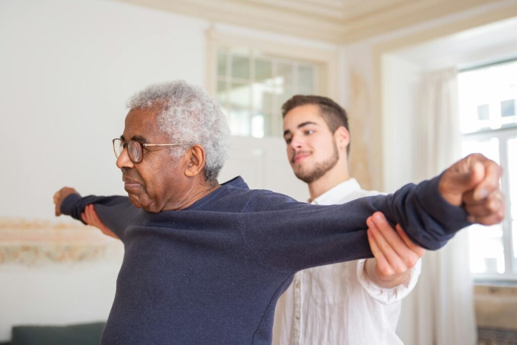 Un enseignant APA accompagne un senior dans sa séance de sport privée.